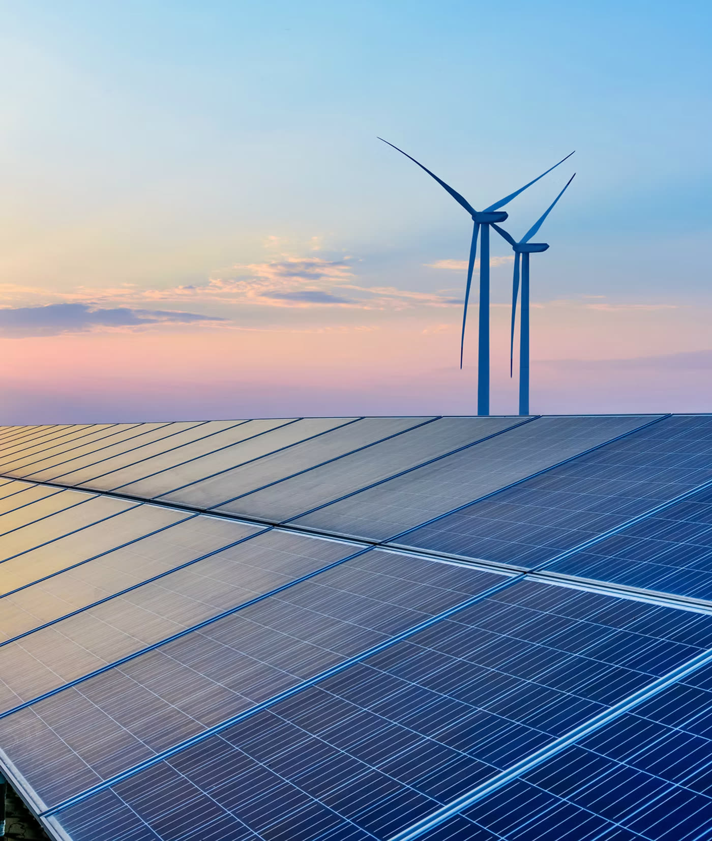 Usina solar e turbinas eólicas ao entardecer